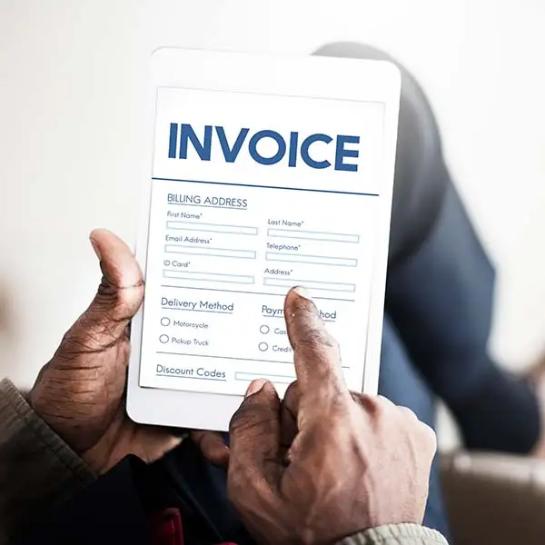 Person filling out a digital invoice form on a tablet