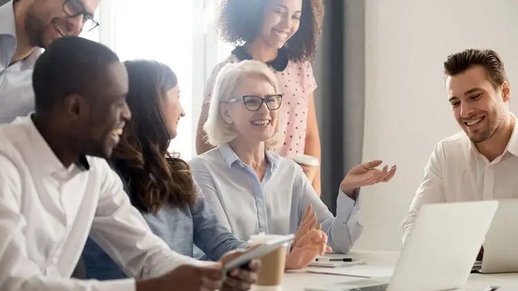 A procurement team meeting with a supplier around a laptop