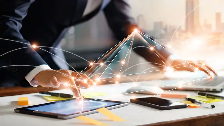 A businessperson taps a tablet showing a connected network of supplier data points