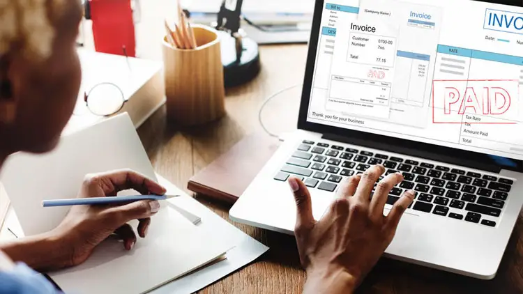 Accounts payable team reviewing purchase order invoices remotely on a laptop