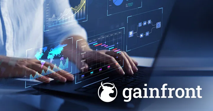 Close-up of hands typing on a laptop beneath translucent dashboard overlays showing a world map, bar and line charts and a workflow diagram, with the Gainfront logo in the corner.
