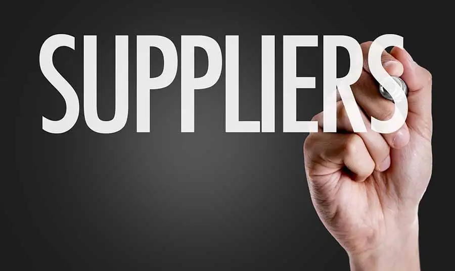 Two business professionals negotiating supplier contract terms across a table